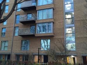 an apartment building with windows on the side of it at Cozy Flat with a Rooftop view in London