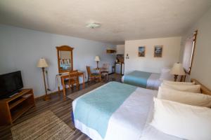 Habitación de hotel con 2 camas y TV en La Kris Inn en Bandon