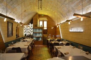 una sala da pranzo con tavoli e sedie bianchi di Forentum Suite a Lavello