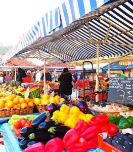 a market with a bunch of fruits and vegetables on display at Appartement coeur du vieux Nice in Nice