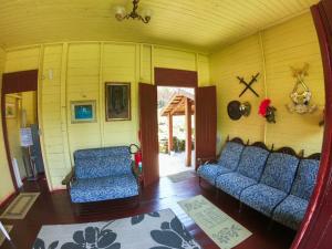 a living room with two blue couches and a chair at Pousada Avalon Paranapiacaba in Paranapiacaba