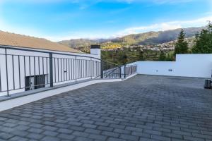 un balcón de una casa con entrada de ladrillo en A&M House II Luxury Holidays Home, en Arco da Calheta