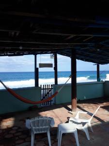 two chairs and a hammock in front of the beach at Casa del mar caribe in Isla Mujeres