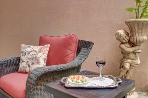 una sedia di vimini con tavolo e bicchiere di vino di The Presidents' Quarters Inn a Savannah