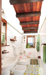 baño con lavabo y aseo y ventana en Villa Dafne, en Alia