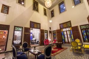 Habitación grande con sillas, mesas y ventanas. en Riad 53 Fes - Luxury Oasis en Fez