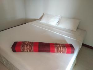 a white bed with two pillows and a plaid blanket on it at Mook Paradise Bungalow in Ko Mook