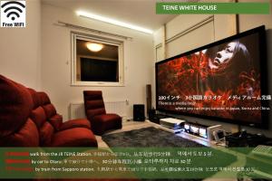 a living room with a tv and a red chair at TEINE WHITE HOUSE in Sapporo