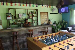 a woman standing behind a counter with a large chessboard at Hostel Tortuguero 7BackPackers in Tortuguero