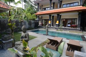 a house with a statue next to a swimming pool at Jiwa's House in Ubud
