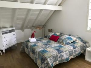 ein Schlafzimmer mit einem Bett und einer Kommode in der Unterkunft EVASION CARAÏBES in Roussel