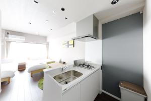 a kitchen with a sink and a refrigerator at TAKUTO STAY OSAKA BENTENCHO in Osaka