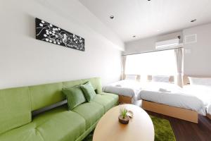 a living room with a couch, coffee table and a lamp at TAKUTO STAY OSAKA BENTENCHO in Osaka