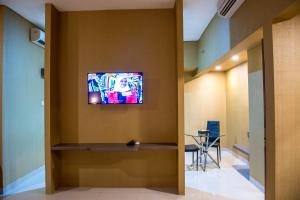 a television on a wall in a hallway at Grand Padis Hotel in Bondowoso