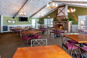 艾昂山的住宿－Pine Mountain Resort，一间带桌椅和壁炉的餐厅