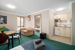 a living room with a kitchen and a dining room at Garden City Motor Inn in Wagga Wagga