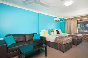 a living room filled with furniture and a couch at Byron Bayside Central Studio Apartments in Byron Bay