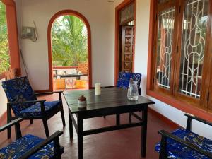 a dining room with a wooden table and chairs at Sampalthivu Beach Villa in Trincomalee