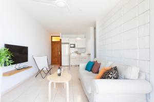 a living room with a white couch and a tv at Las Américas Downtown : Prime location accomm. in Arona