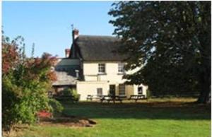 una casa blanca con una mesa de picnic delante de ella en Blue Ball Inn, Sandygate, Exeter en Exeter