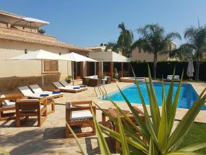 a swimming pool with tables and chairs next to a house at Hotel La Gastrocasa - Adults Only in Gandía
