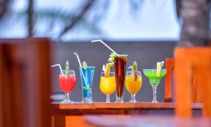 a row of different colored drinks in glasses on a table at Ceylon Sea Hotel in Tangalle