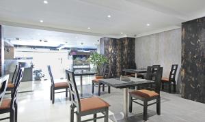 a dining room with tables and chairs in a restaurant at Itsy By Treebo - Jansi Residency in Coimbatore