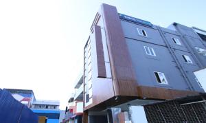un alto edificio con facciata in legno su una strada di Itsy Hotels Jansi Residency a Coimbatore