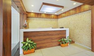 un atrio con una porta di legno e due piante in vaso di Itsy Hotels Jansi Residency a Coimbatore
