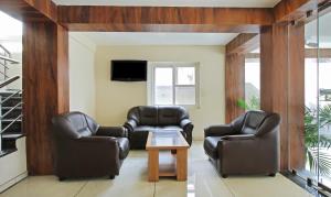 two leather chairs and a table in a living room at Itsy By Treebo - Jansi Residency in Coimbatore