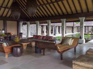 un soggiorno con un divano, un tavolo e delle sedie di Sira Beach House a Tanjung