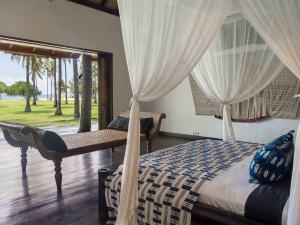 una camera da letto con un letto con tende e una finestra di Sira Beach House a Tanjung Altre 46 foto