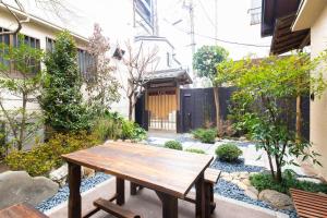 uma mesa de madeira no meio de um jardim em Kagurazaka Retro BAR & HOTEL em Tóquio