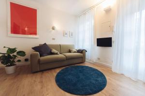 ein Wohnzimmer mit einem Sofa und einem blauen Teppich in der Unterkunft Accogliente monolocale alla Gran Madre in Turin