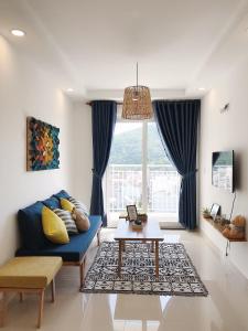 un salon avec un canapé bleu et une table dans l'établissement Căn hộ Nghỉ Dưỡng Aparment Melody Vũng Tàu - Tomorrow Homestay 1, à Vung Tau