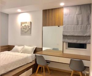 a bedroom with a bed and a desk and two chairs at Căn hộ Nghỉ Dưỡng Aparment Melody Vũng Tàu - Tomorrow Homestay 1 in Vung Tau