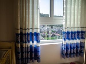 a window with blue and white curtains in a room at Căn hộ Nghỉ Dưỡng Aparment Melody Vũng Tàu - Tomorrow Homestay 1 in Vung Tau