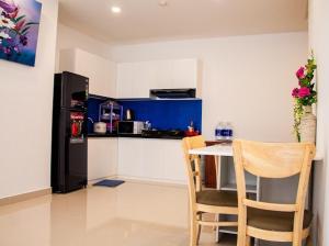 a kitchen with a table and chairs and a refrigerator at Căn hộ Nghỉ Dưỡng Aparment Melody Vũng Tàu - Tomorrow Homestay 1 in Vung Tau