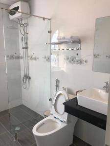 biała łazienka z toaletą i umywalką w obiekcie Ngoc Lan Hotel and Coffee w mieście Ðưc Trọng