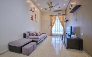 a living room with a couch and a tv at Esdi Homestay Malacca in Malacca