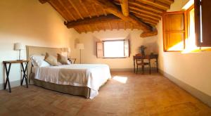 a bedroom with a bed in a room with wooden ceilings at Agriturismo Villa Gorgognano in Certaldo