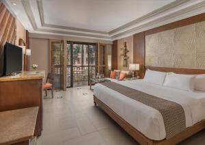 a bedroom with a large bed and a television at Henann Regency Resort and Spa in Boracay