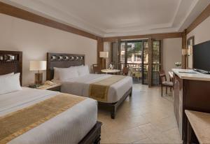 a hotel room with two beds and a television at Henann Regency Resort and Spa in Boracay