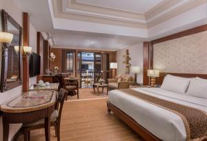 a hotel room with a bed and a living room at Henann Regency Resort and Spa in Boracay