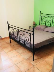 ニースにあるAppartement coeur du vieux Niceのタイルフロアのベッドルーム1室(黒いベッド1台付)