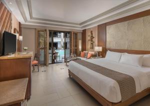 a bedroom with a large bed and a living room at Henann Regency Resort and Spa in Boracay
