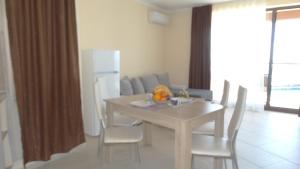 a kitchen and dining room with a table and chairs at Akrotiria Beach Apart Complex in Nesebar