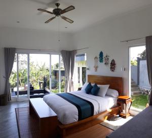 a bedroom with a large bed with a ceiling fan at Wanagiri Cosmic Nature Villa in Bedugul