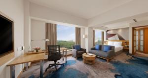 a hotel room with a bed and a desk at Novotel Hyderabad Convention Centre in Hyderabad