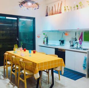 eine Küche mit gelbem Tisch und Stühlen in der Unterkunft Come Home Travel in Tainan